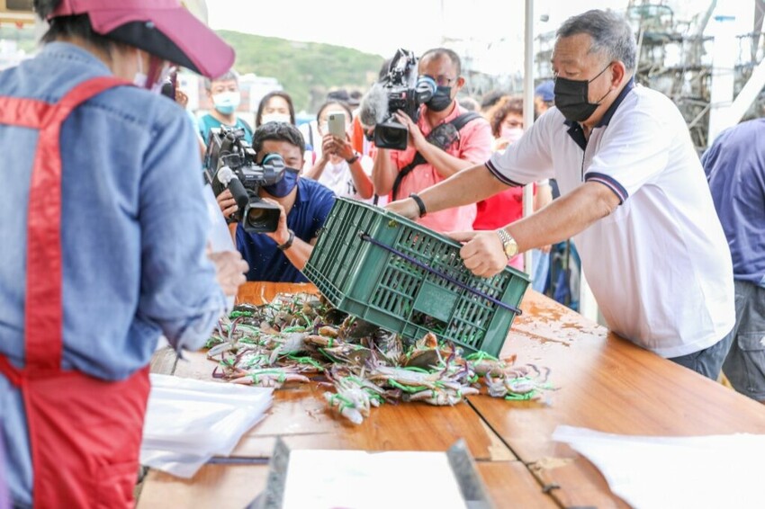 圖四：限量福袋399元，絕對都是生猛活蟹，圖中漁民將籃中活蟹倒到桌上準備分裝福袋。