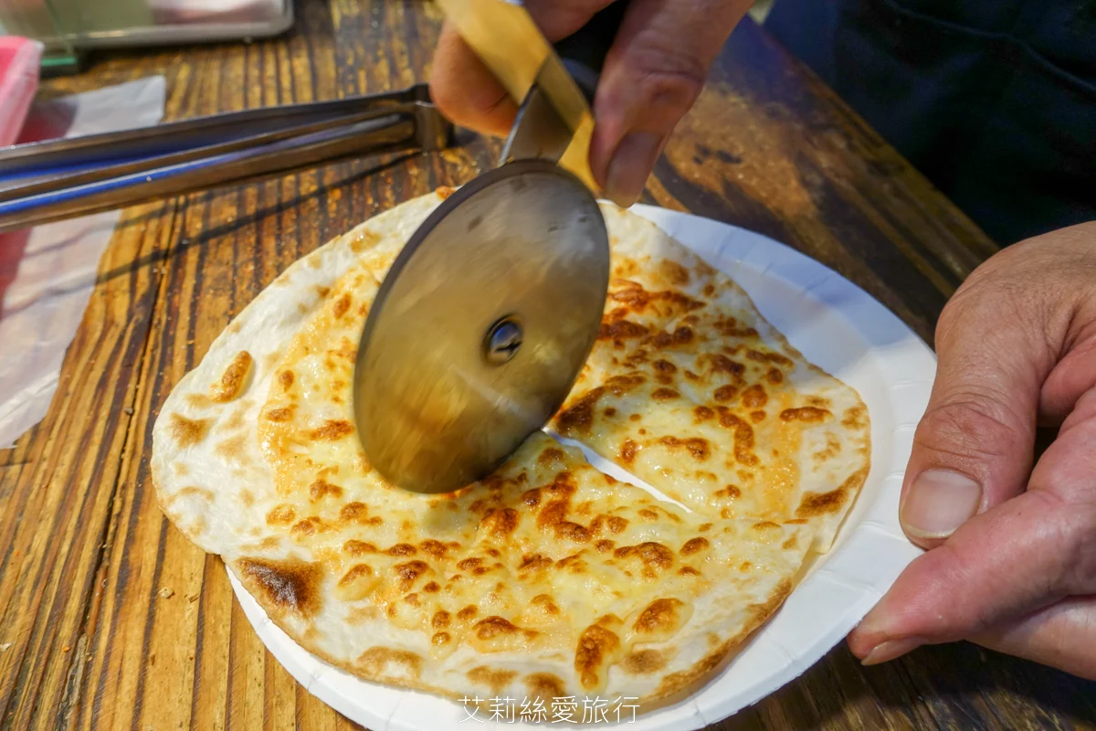 饒河夜市必吃 幸花明太子起司烤餅 餅皮薄脆香香鹹鹹明太子淡淡起司香味 外觀像PIZZA但沒有PIZZA的油膩口感 份量適中好吃沒負擔！