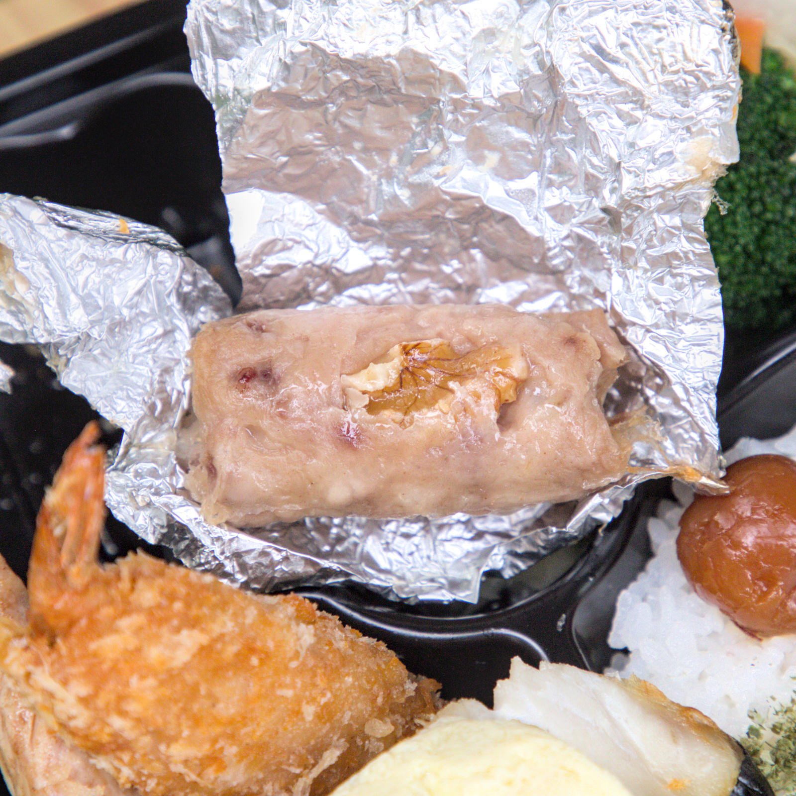 紅蕃茄小資便當,獨家美味的松子捲 紅蕃茄小資便當中的松子捲特寫,這道店家獨家研發的特色料理,將香氣濃郁的松子與豬肉巧妙結合,口感豐富且獨特,是在其他地方吃不到的獨家美味。