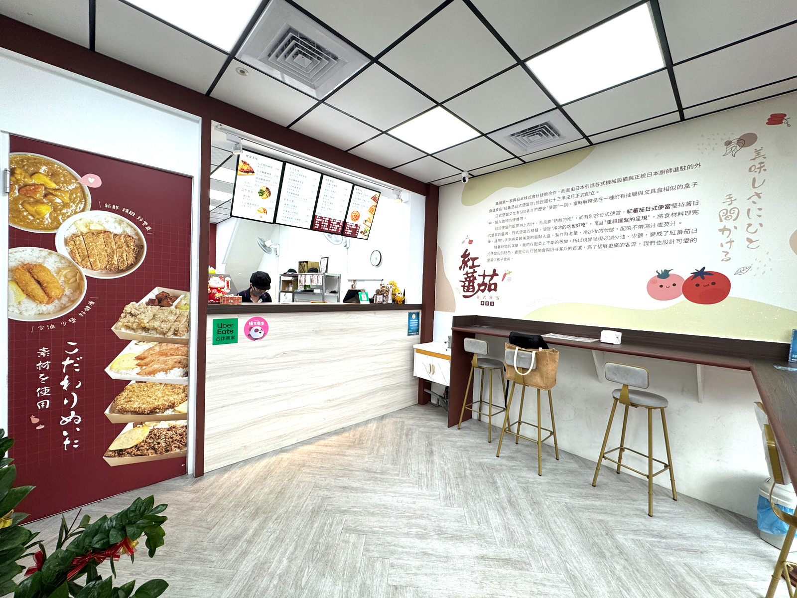 紅蕃茄日式便當溫馨日式風格店內環境,木質櫃檯與高腳椅 紅蕃茄日式便當的店內環境,裝潢以木質紋理的櫃檯為主,搭配簡約的高腳椅,整體空間潔淨整齊,營造出溫馨且充滿日式風情的氛圍,主要提供顧客外帶等候使用。