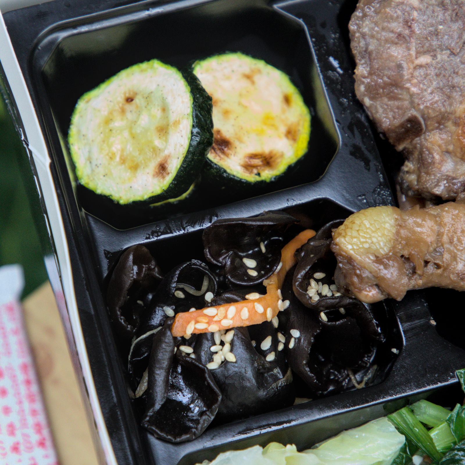 紅蕃茄客製化便當的烤櫛瓜與涼拌木耳 紅蕃茄客製化便當中的配菜特寫,烤櫛瓜與黑木耳絲,展現了店家對配菜的用心,確保每一份便當都能提供均衡營養與多樣口感。