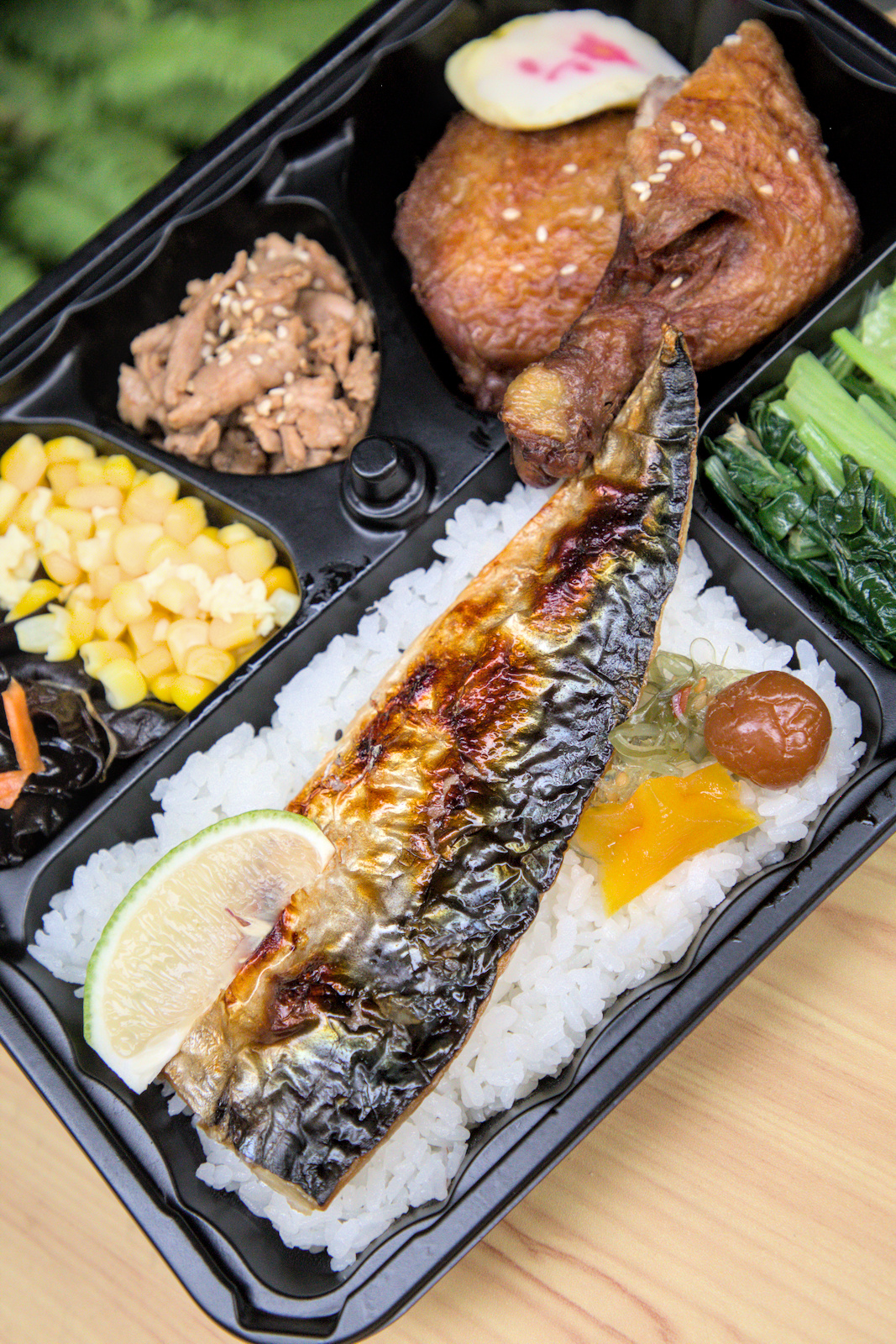 紅蕃茄三拼便當的豐盛主菜與配菜 紅蕃茄250元三拼氣派組合便當的近照,主菜份量十足,擺盤精緻,配菜如甜玉米粒、涼拌木耳、爽脆高麗菜等,讓便當內容更加豐富。