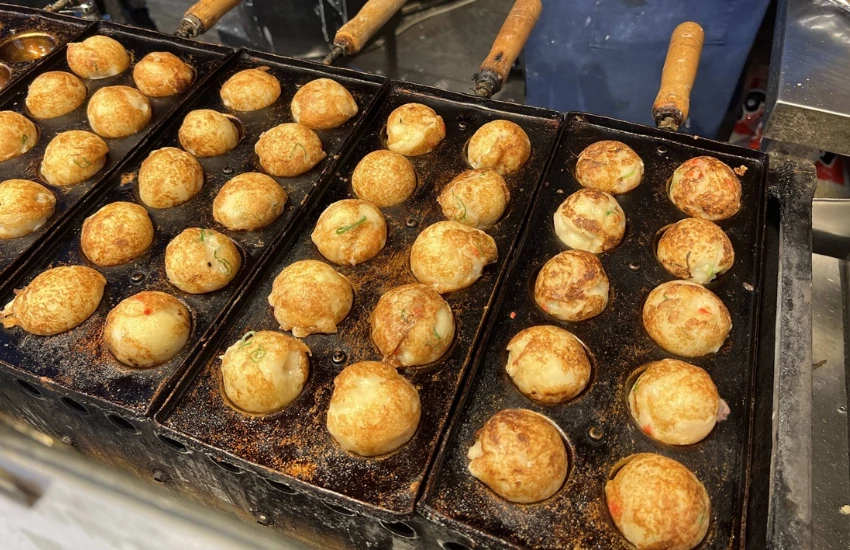 ▲麵糊倒進圓形鐵板，熟練地翻轉、轉動，每一顆都膨脹得圓滾滾的，熱氣和香味隨之撲鼻而來。